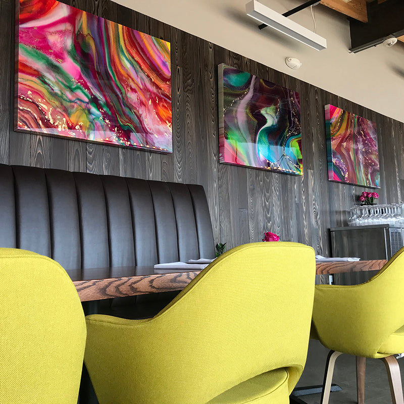 A cozy dining area featuring vibrant abstract art on the wooden wall .