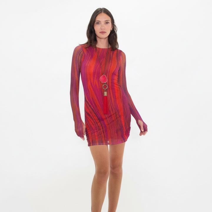 Woman wearing a red and orange patterned dress on a white background