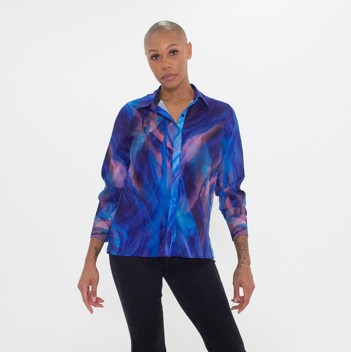 Person wearing a blue tie-dye shirt and black pants on a white background