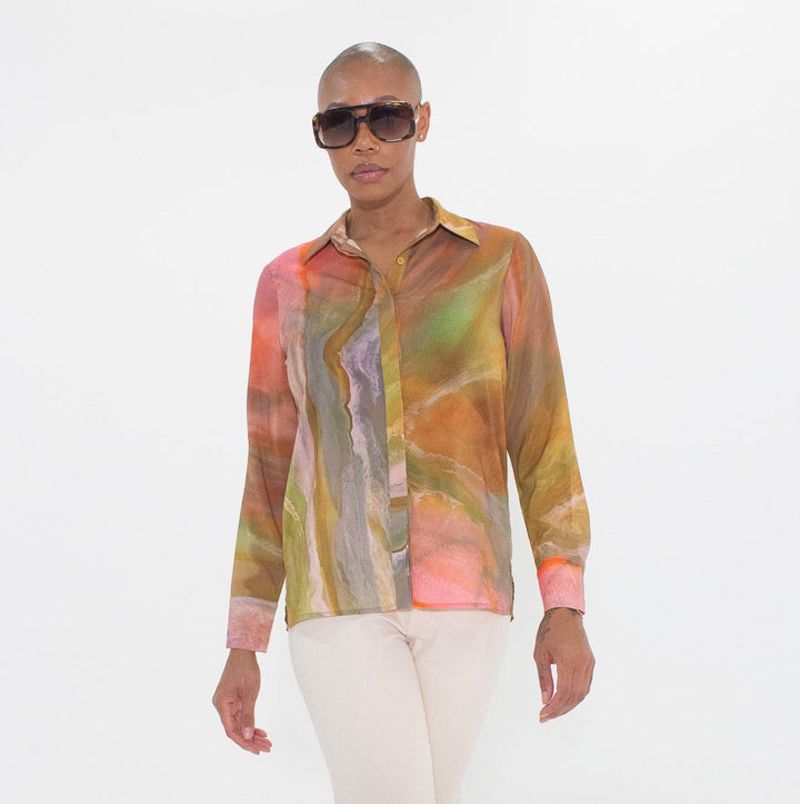 Person wearing a colorful shirt and white pants on a white background