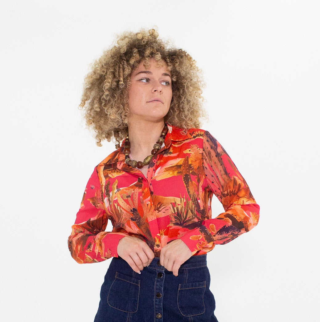 Person wearing a colorful shirt, denim skirt, and brown boots on a white background
