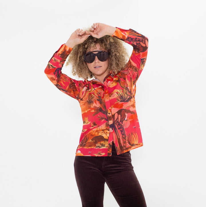 Person wearing a colorful shirt and dark pants on a white background