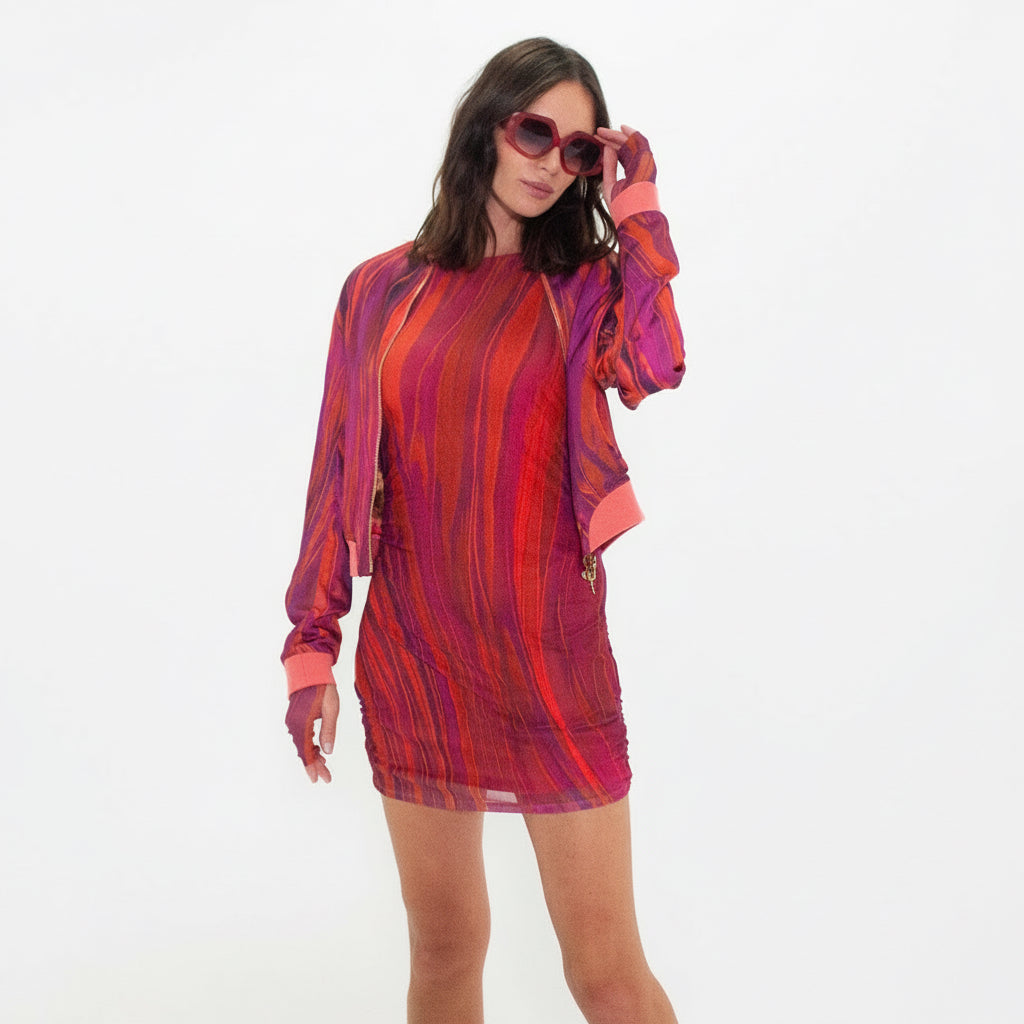 Woman wearing a red and orange patterned dress on a white background