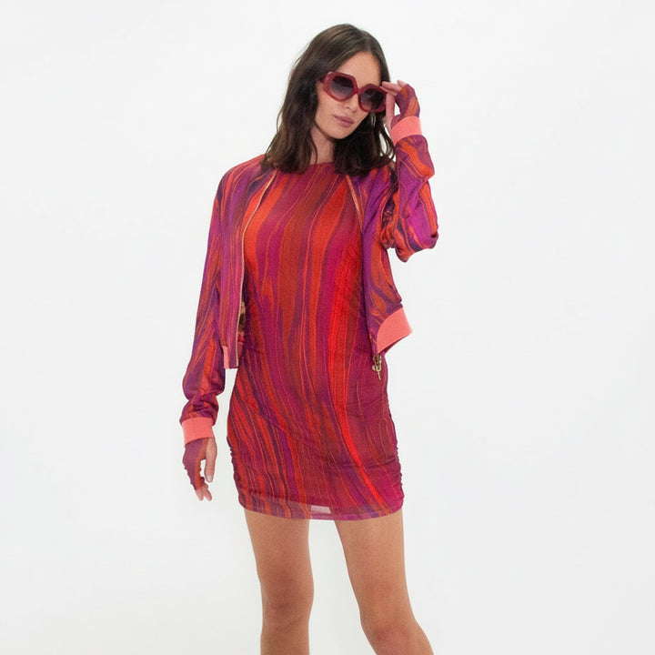 Woman wearing a red and orange patterned dress on a white background