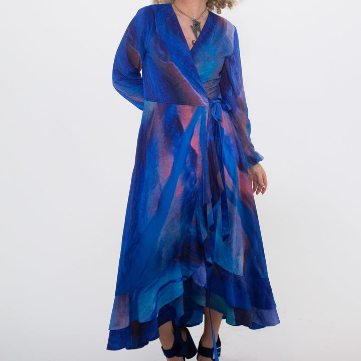 Woman wearing a blue and purple patterned dress on a white background