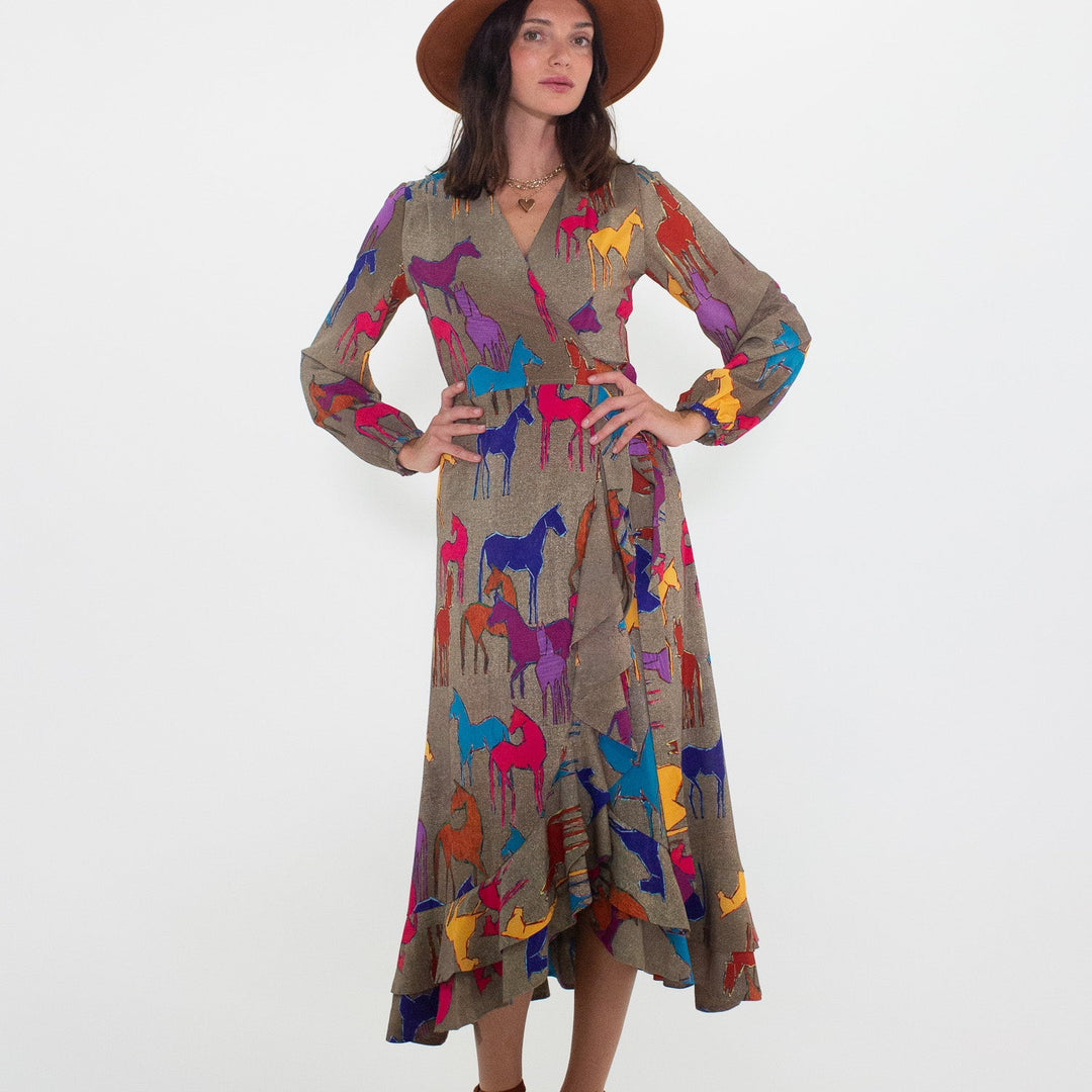 Woman wearing a patterned dress with colorful horse designs on a white background