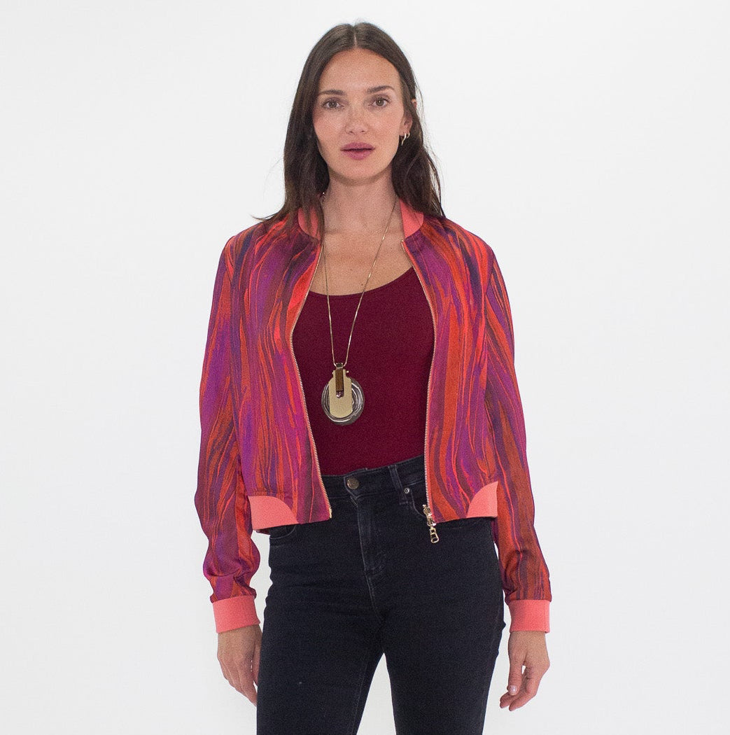 Woman wearing a colorful shirt, red top, and black flared jeans on a white background